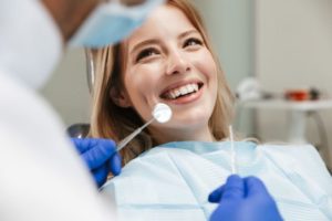 patient smiling in dental chair while dentist talks to her