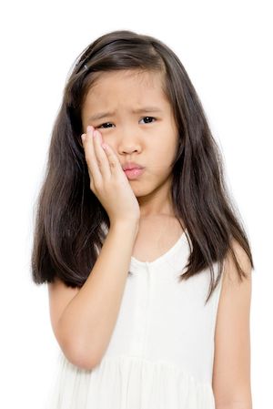 girl holding her mouth from tooth pain