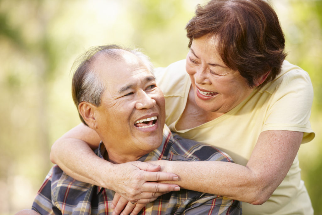 man with permanent dentures smiling with his wife